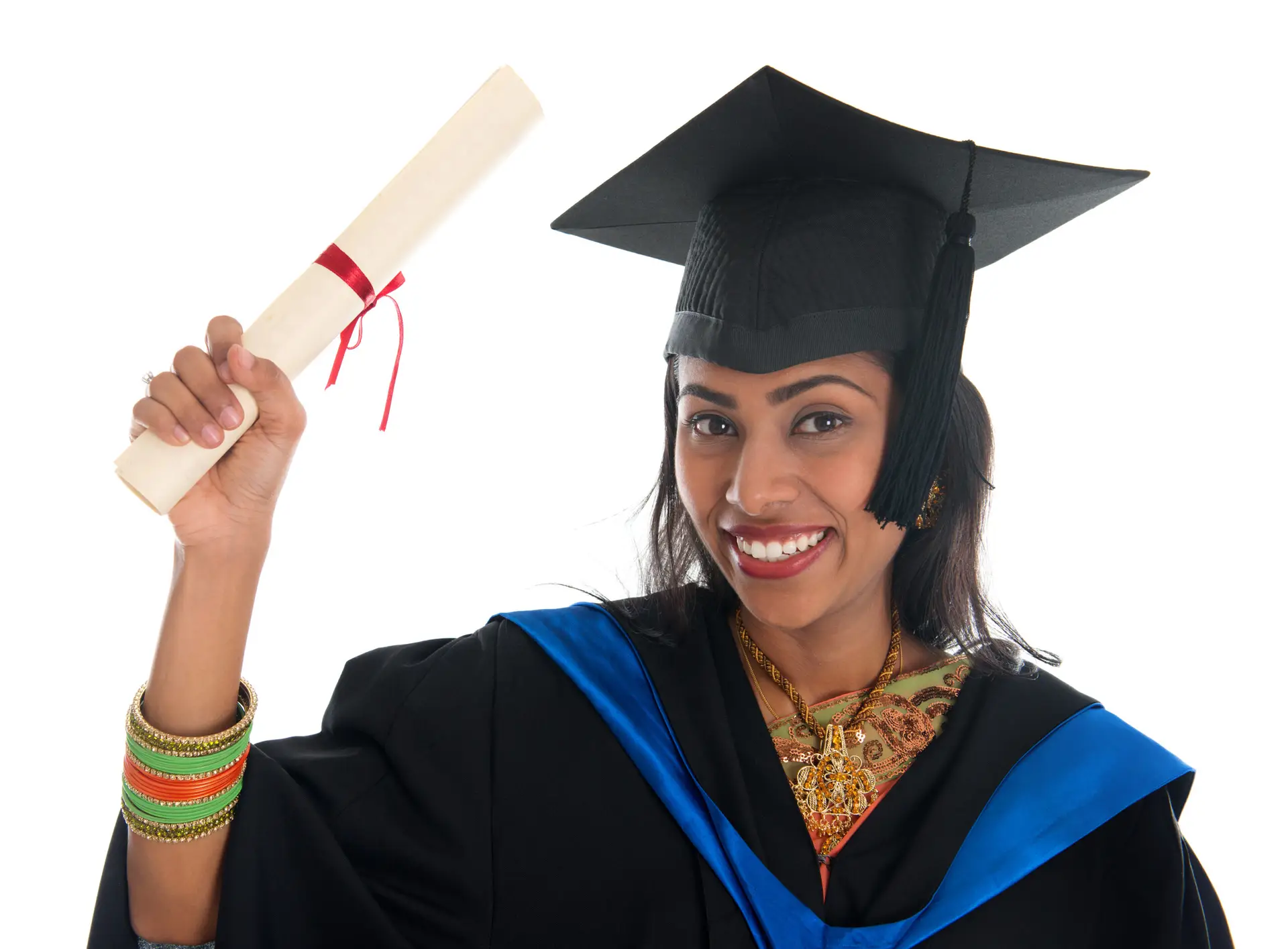 Happy Indian adult student in graduation gown and cap holding diploma certificate. Portrait of mixed race Asian Indian and African American female model standing isolated on white background.